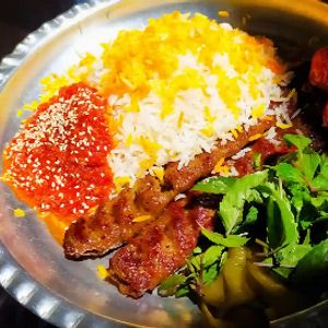 برنج با سس مخصوص ، گوجه ، دو سیخ کوبیده و دورچین