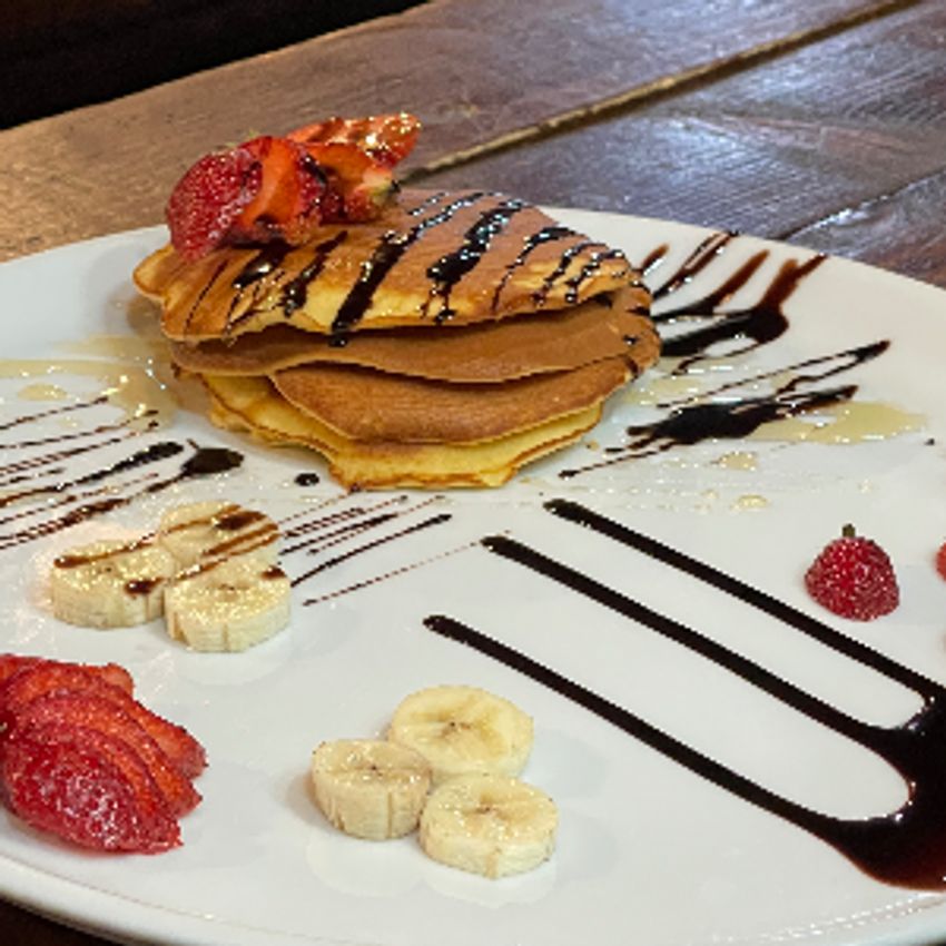 پنکیک و موز و توت فرنگی و سس شکلات و عسل