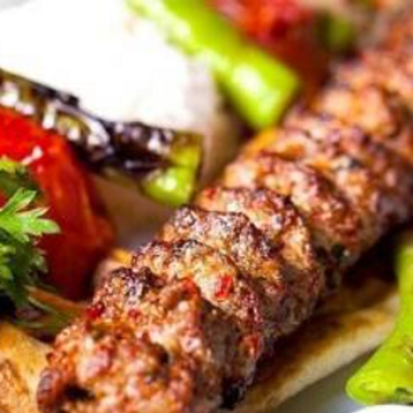 یک سیخ کباب بناب گوسفندی220گرمی که داخل آن فلفل دلمه و گوجه وسبزی  خورد شده وجود دارد